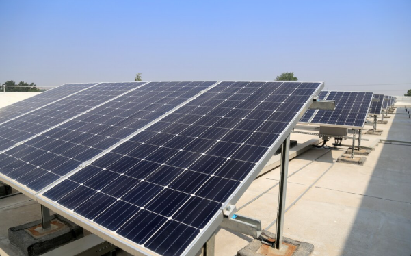 Solar panels mounted on a flat rooftop under a clear sky
